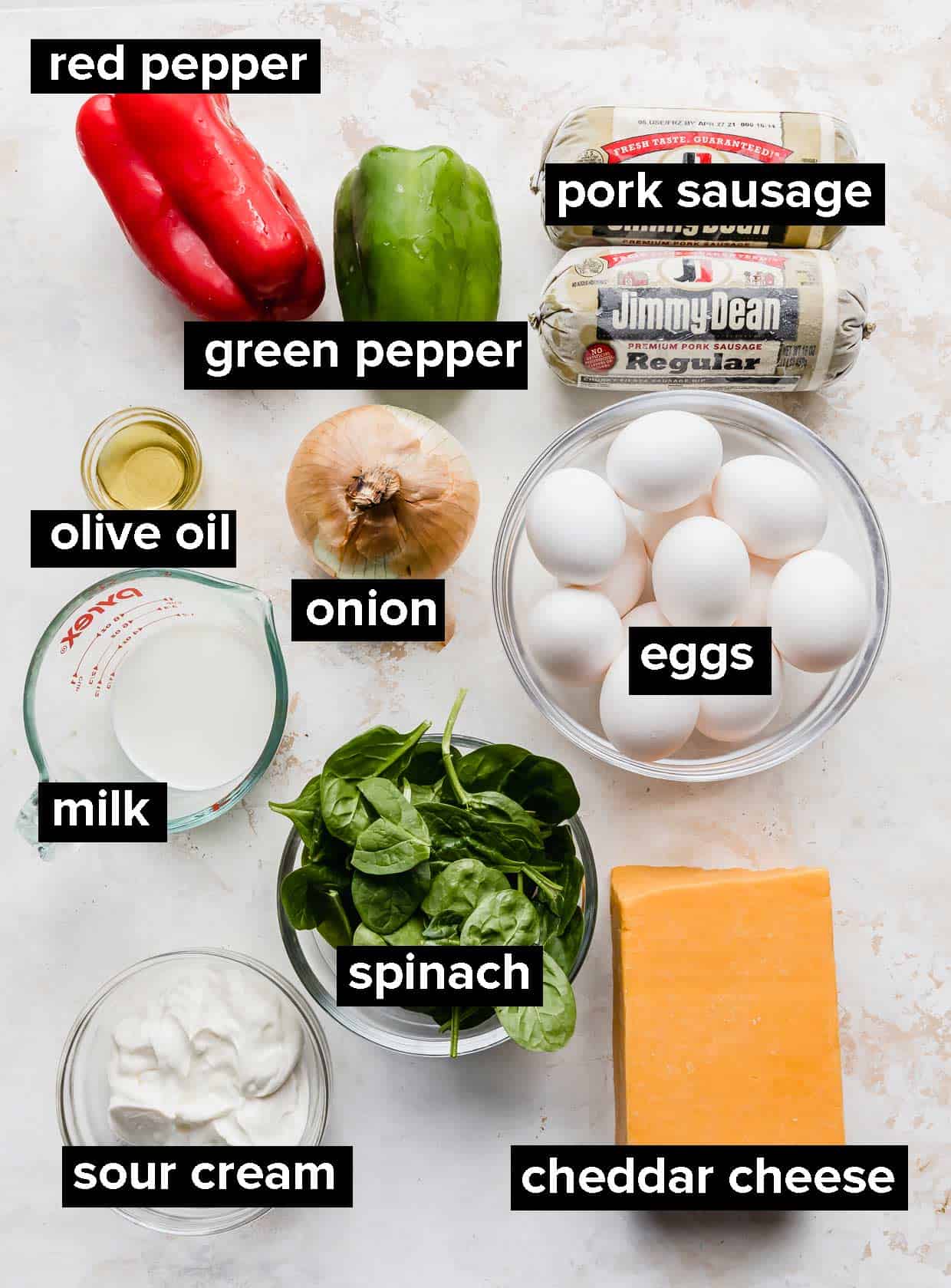 Ingredients used to make breakfast casserole on a textured white background.