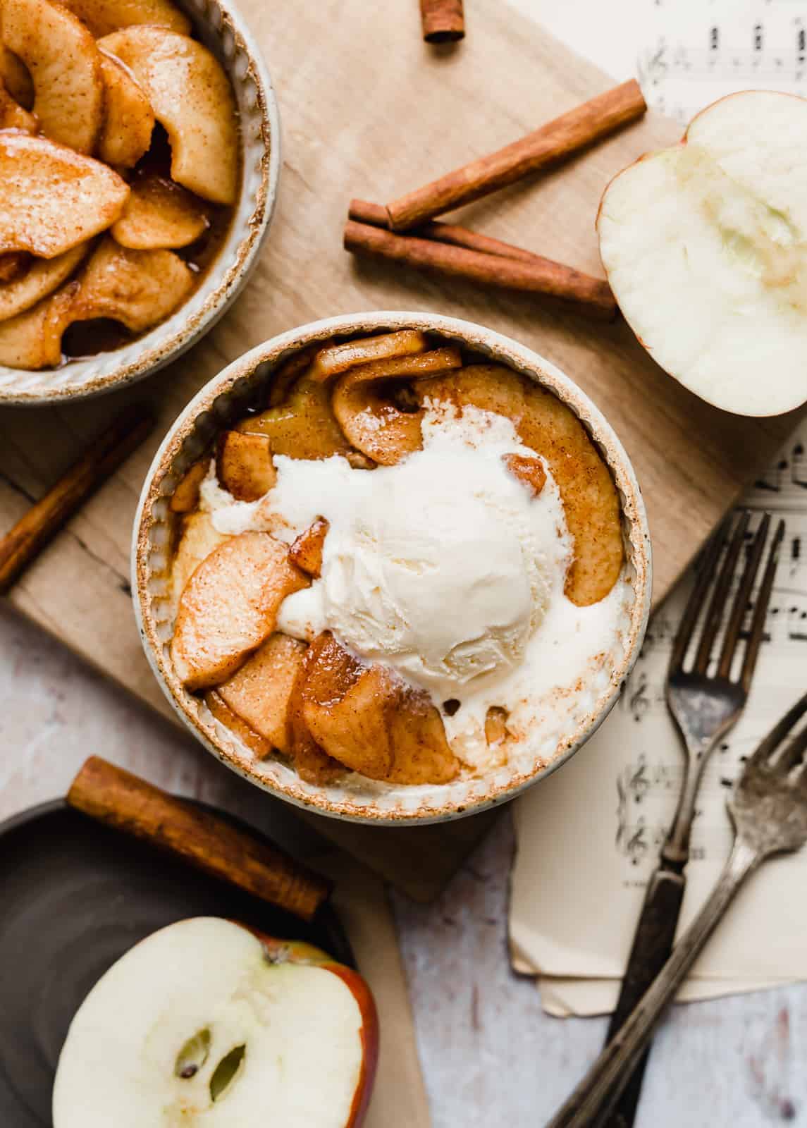 Overhead photo of Cinnamon Baked Apples in a bowl topped with a scoop of vanilla ice cream.