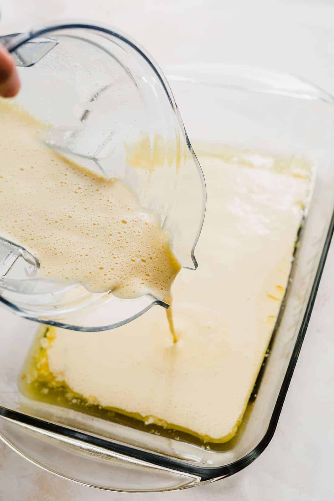 German Pancake batter being poured into a thirteen by nine inch casserole dish.