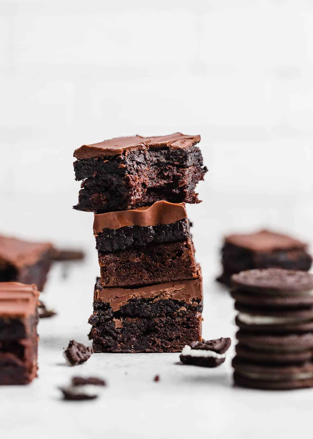 Three Oreo Truffle Brownies stacked on top of each other against a white background.