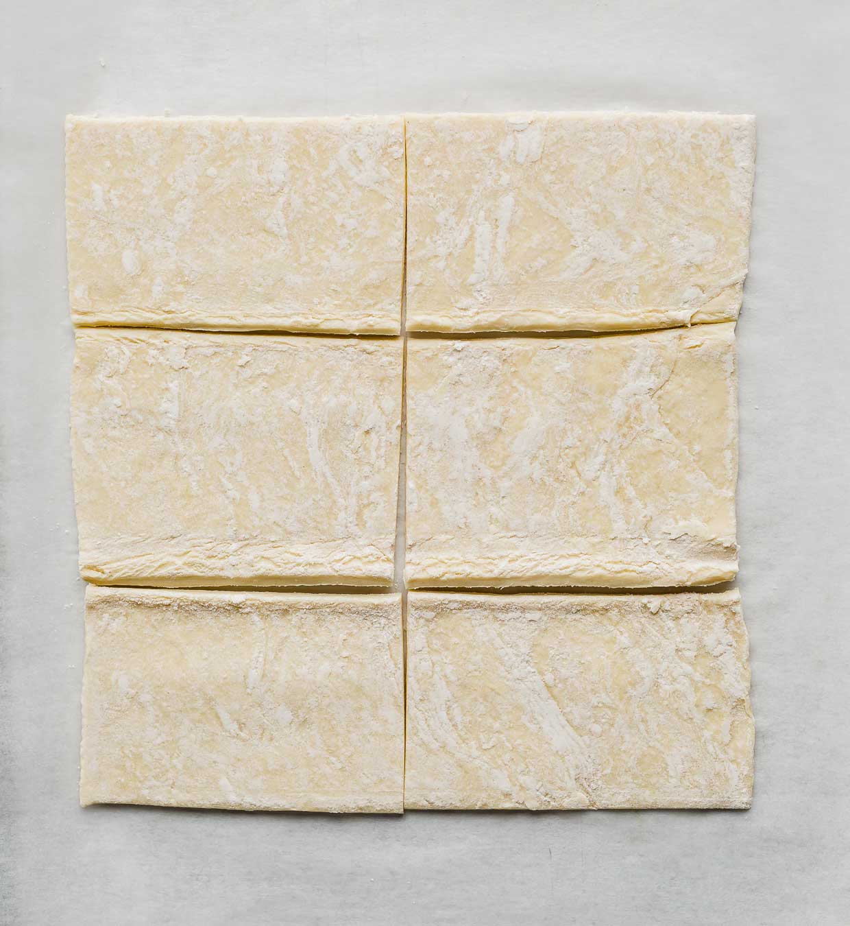 A puff pastry sheet cut into six rectangles, used to make a berry toaster strudel at home.