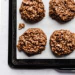 A chocolate peanut butter oatmeal no bake cookie on a white parchment paper.