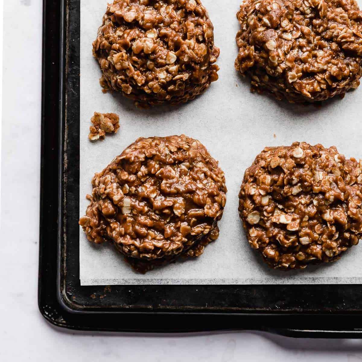 A chocolate peanut butter oatmeal no bake cookie on a white parchment paper.