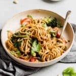 Peanut butter noodles with vegetables on a pasta plate.