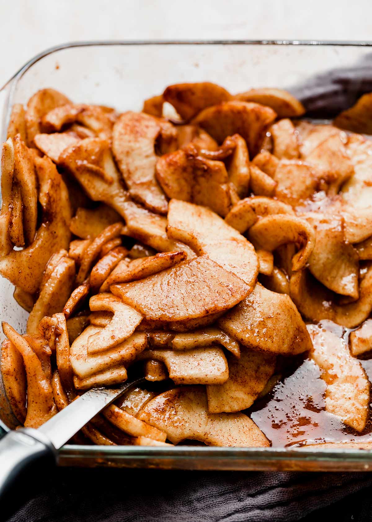 Sliced Cinnamon Baked Apples in a glass baking dish.