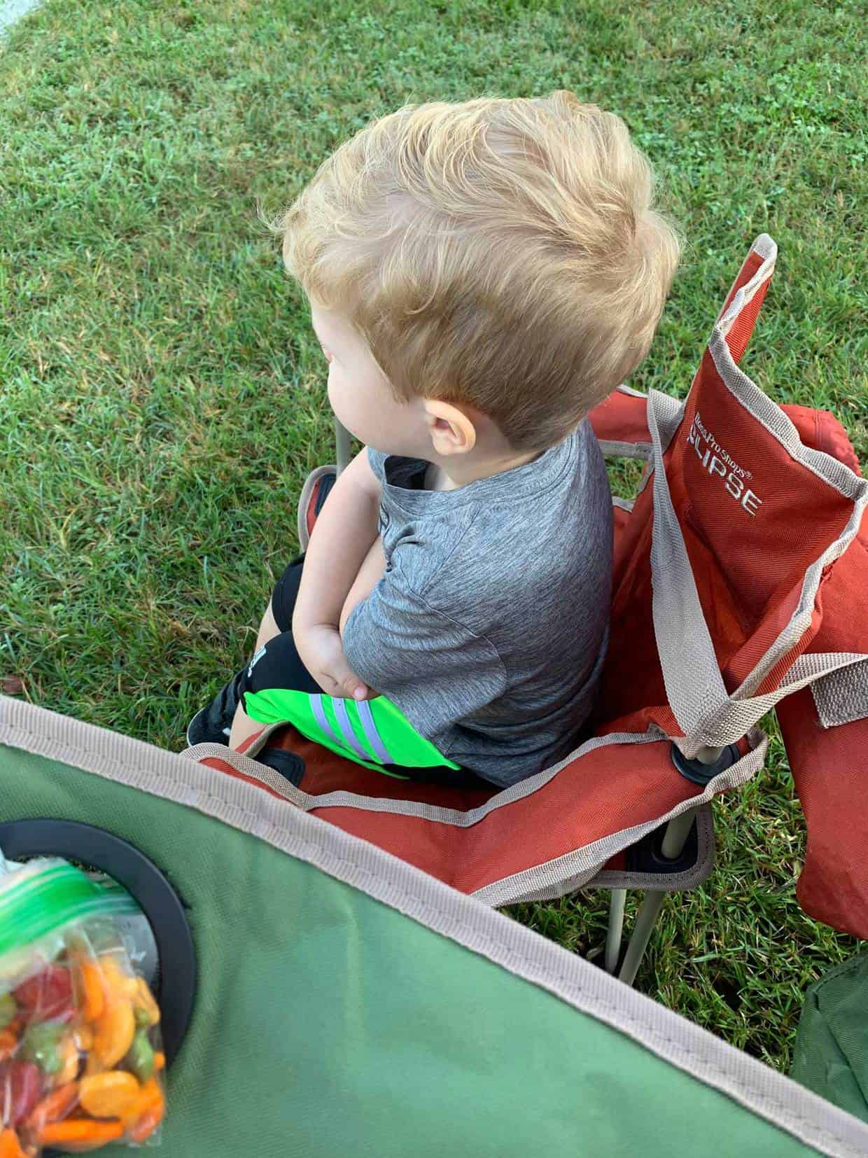 A boy sitting in a chair with his arms folded. 