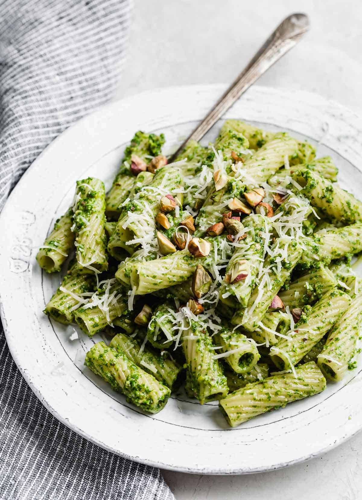 Kale Pesto Pasta with rigatoni noodles on a white plate.