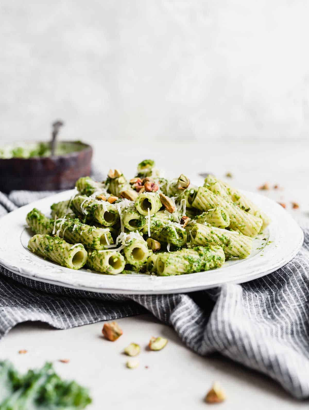 Rigatoni Kale Pesto Pasta on a white plate against a white background.