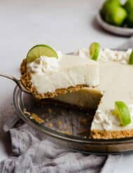 A metal spatula holding up a slice of key lime pie.
