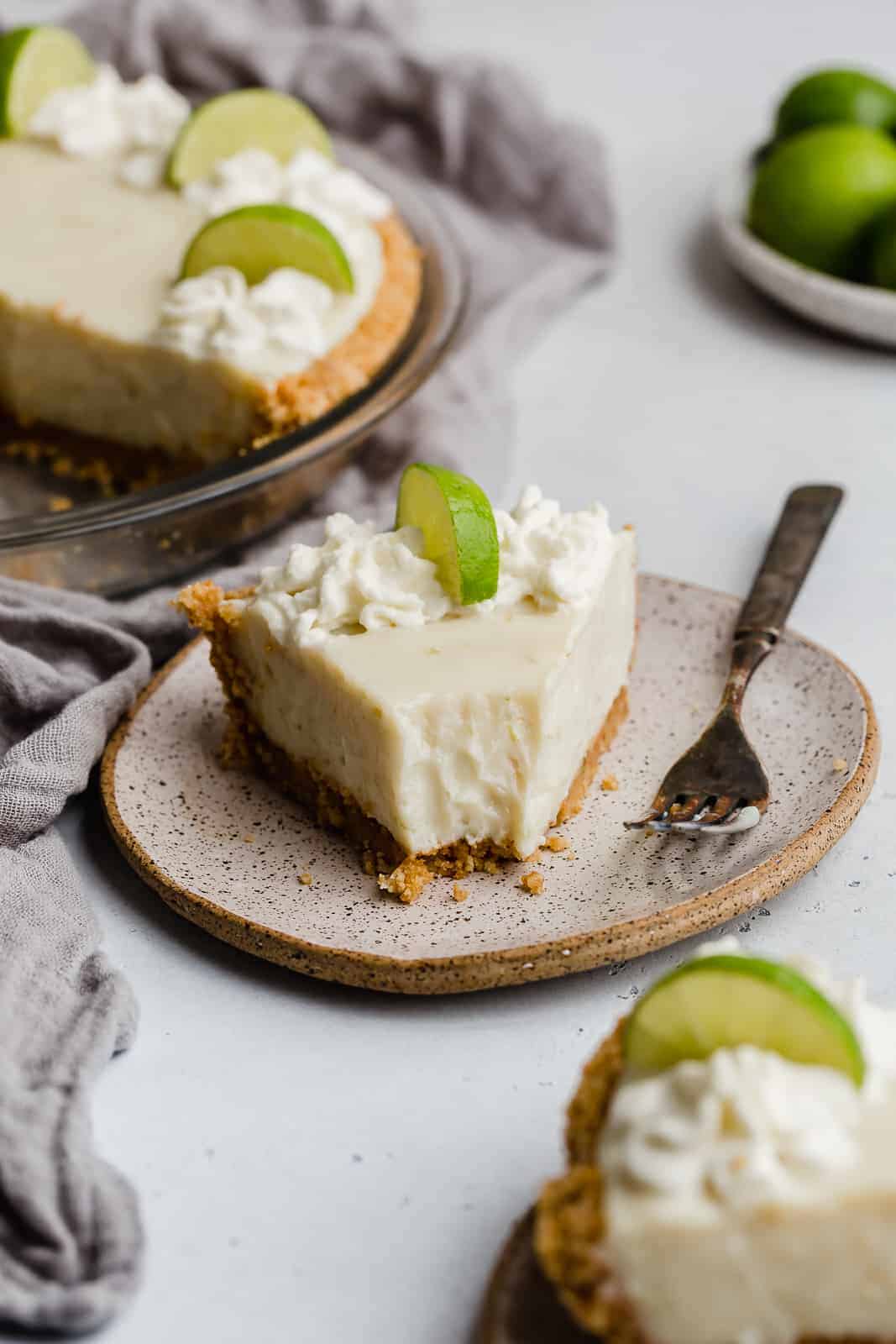 A slice of key lime pie on a plate, with a fork resting beside it.