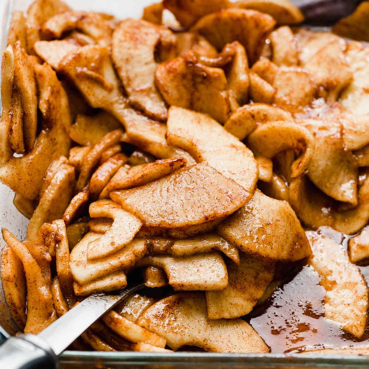 Cinnamon Baked Apples in a cinnamon mixture in a glass pan.