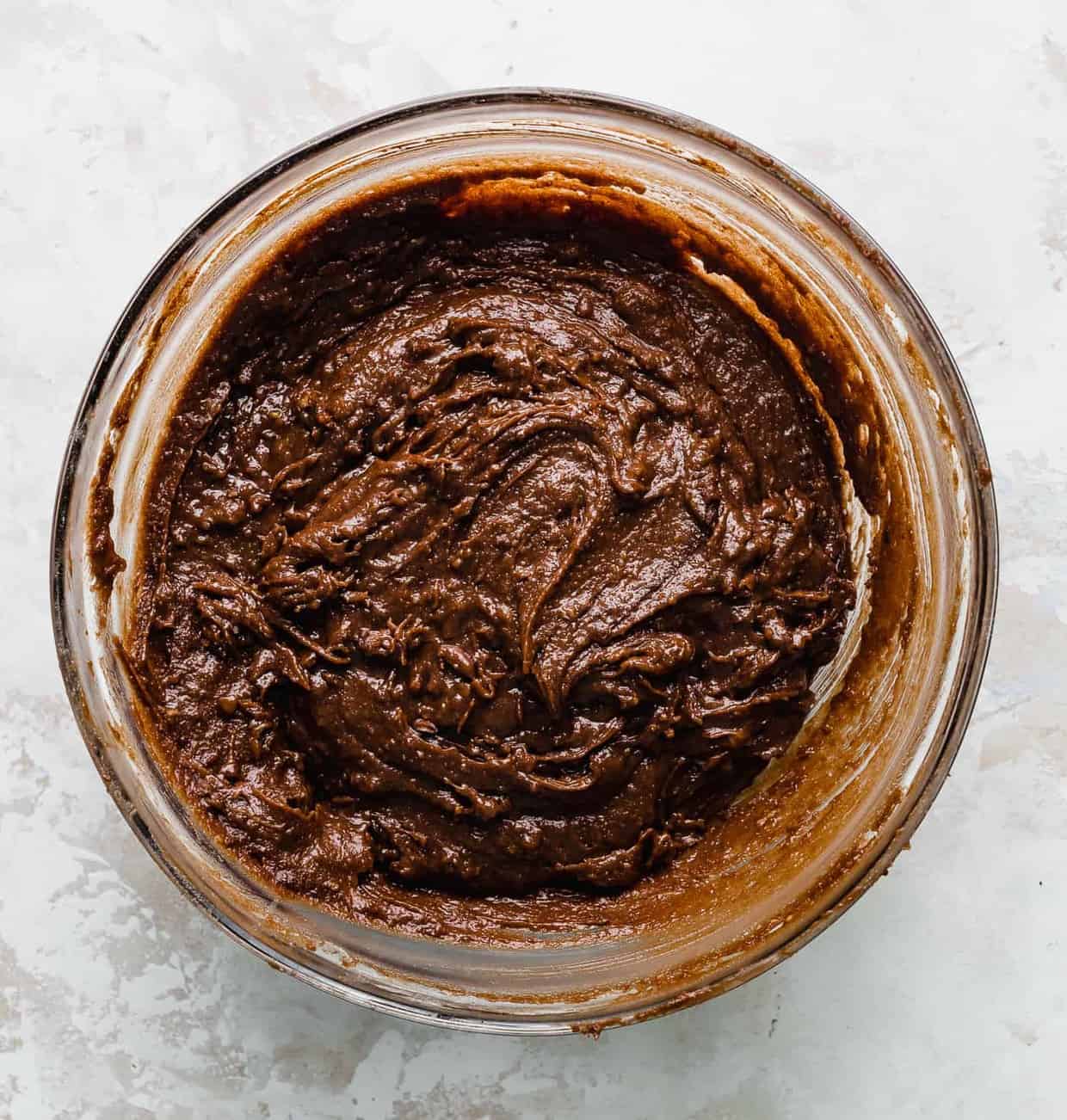 A bowl full of dark brown brownie batter.