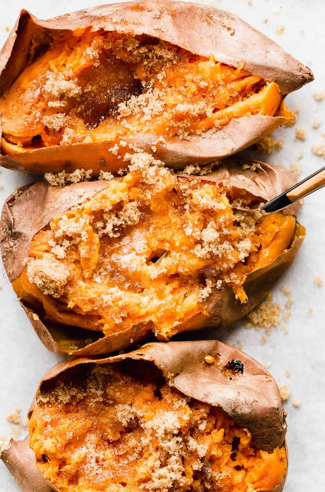 A fork scooping up some baked sweet potato.