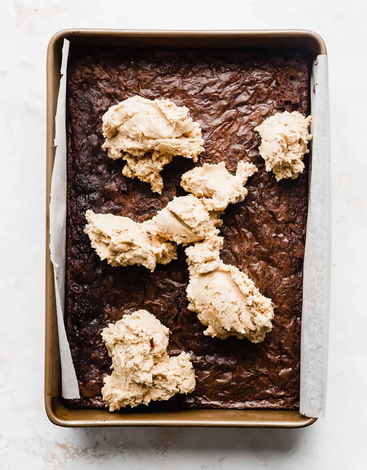 A pan of brownies topped with dollops of Buckeye peanut butter brownie filling.