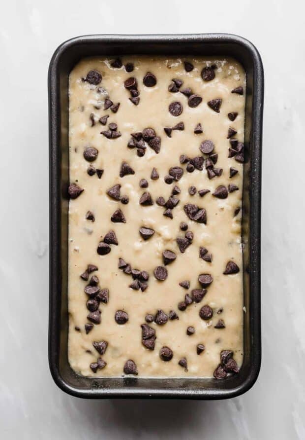 A loaf pan full of Chocolate Chip Banana Bread batter.