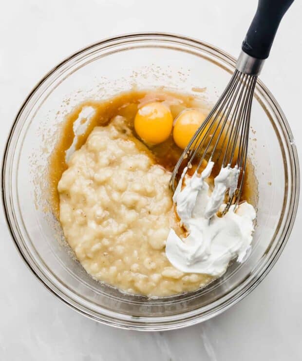 Mashed bananas, yogurt, and eggs, in a glass bowl.