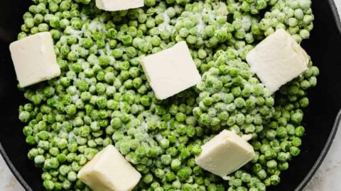 Frozen peas, cubed butter, sugar, and minced garlic in a skillet.