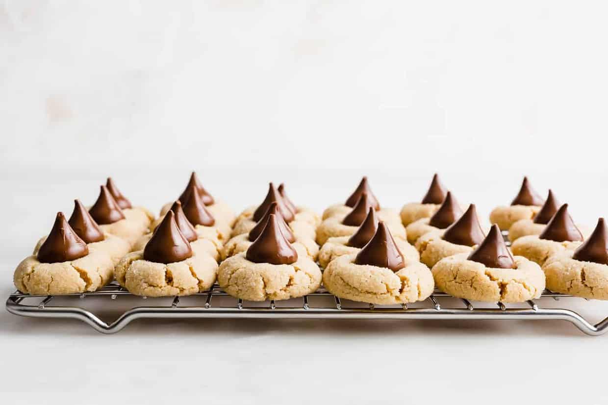 Peanut Butter Blossom cookies lined up on a cooling rack.