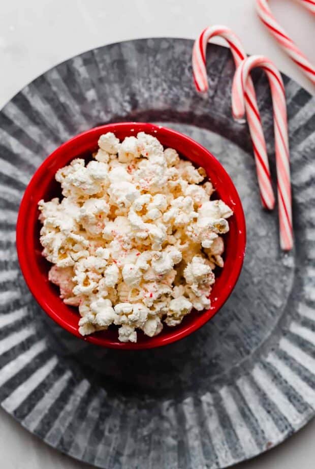 A bowl of popcorn on a metal plate.