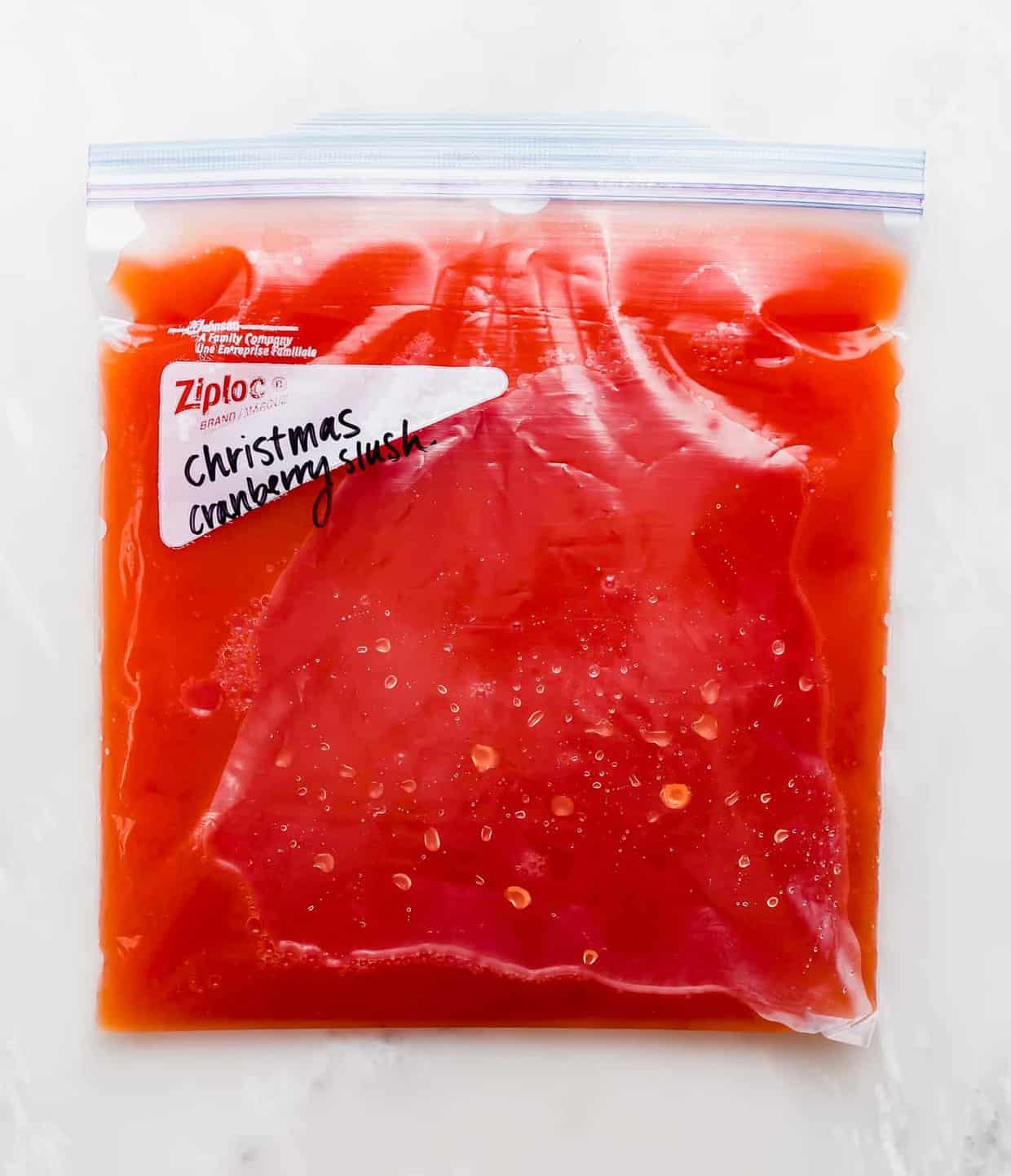 A gallon size freezer bag full of red juice.