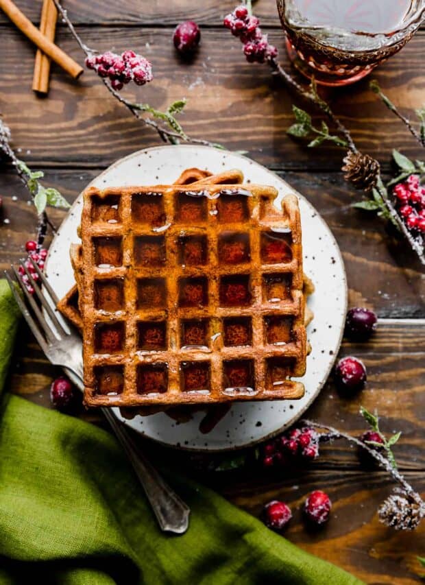 Gingerbread Waffles on a white plate against a wooden background.