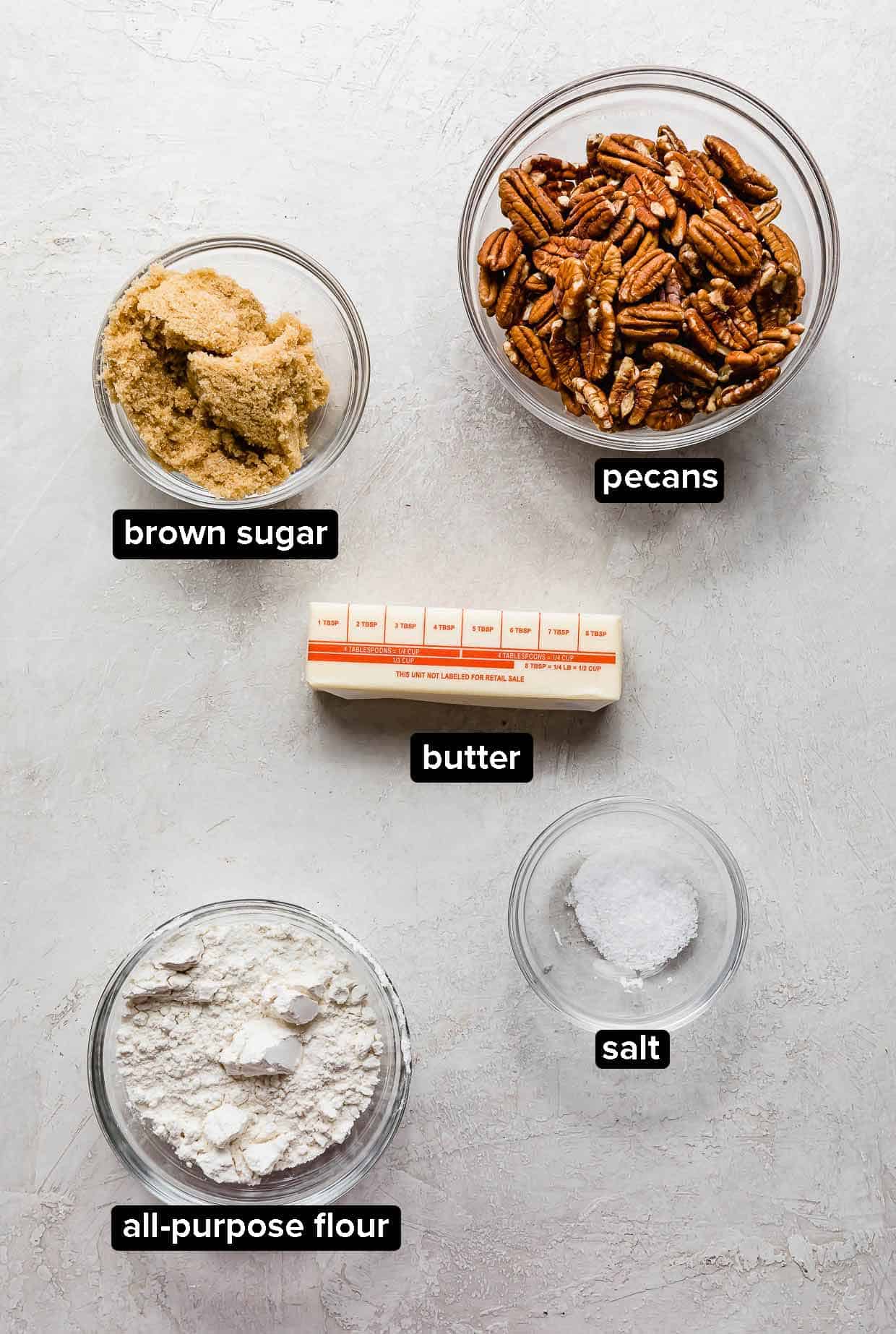 Easy Sweet Potato Casserole pecan topping ingredients portioned into glass bowls on a light gray background.