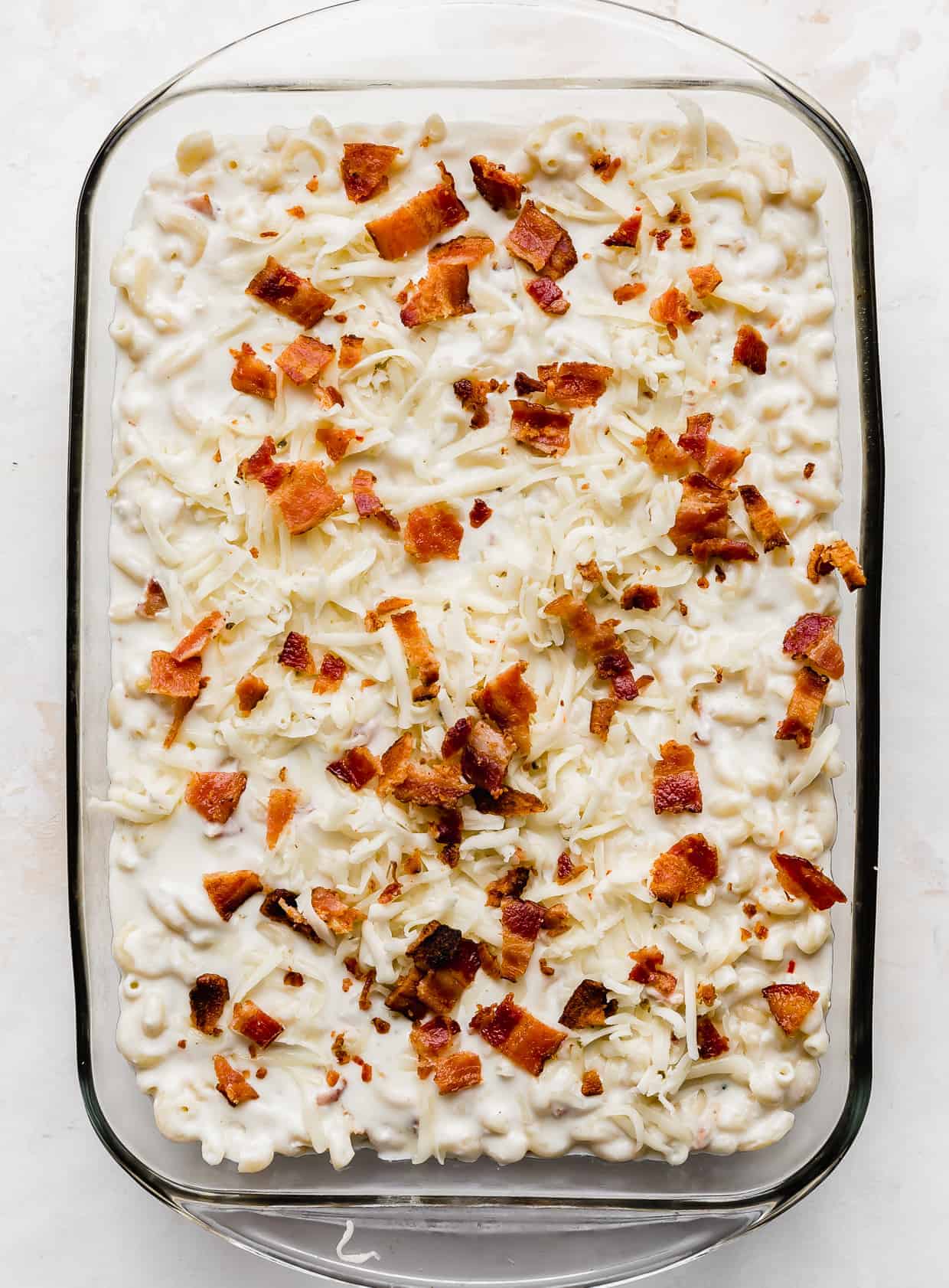 A casserole dish with Bacon Pepper Jack Mac and Cheese in it against a white background.
