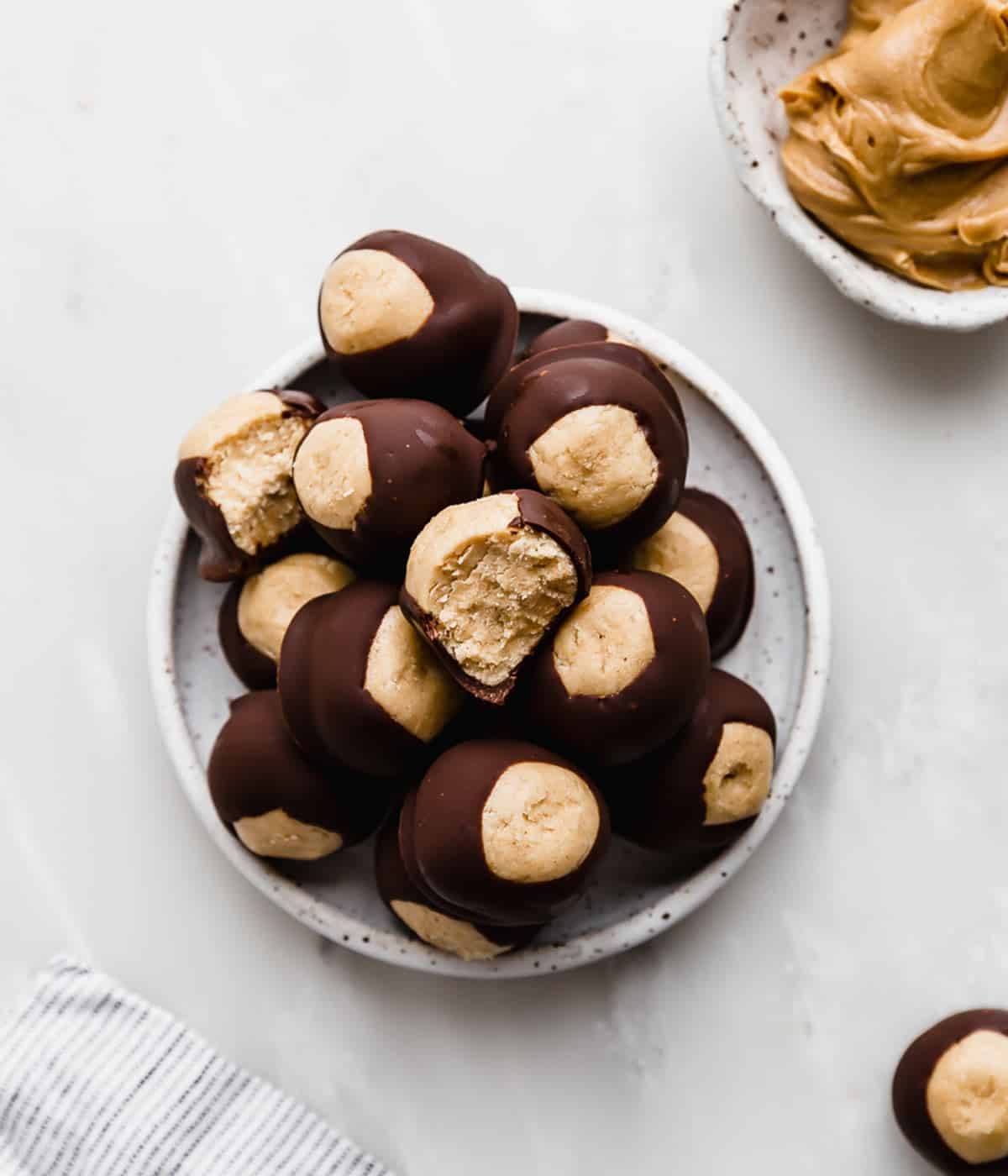 Buckeye balls on a white plate that's on a marble table.