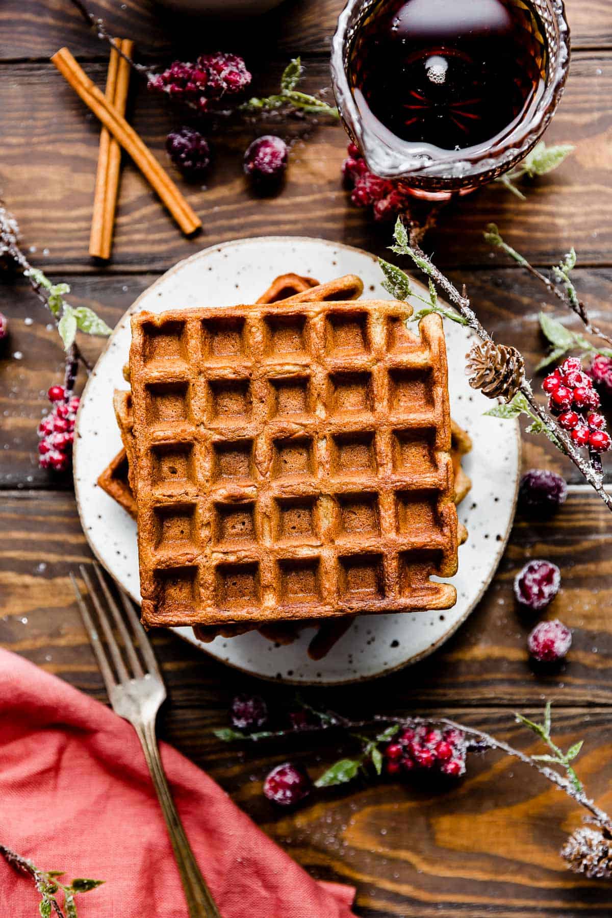 square Gingerbread Waffles on a white plate on a brown wooden background.