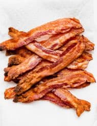 Strips of crispy bacon on a white paper towel.