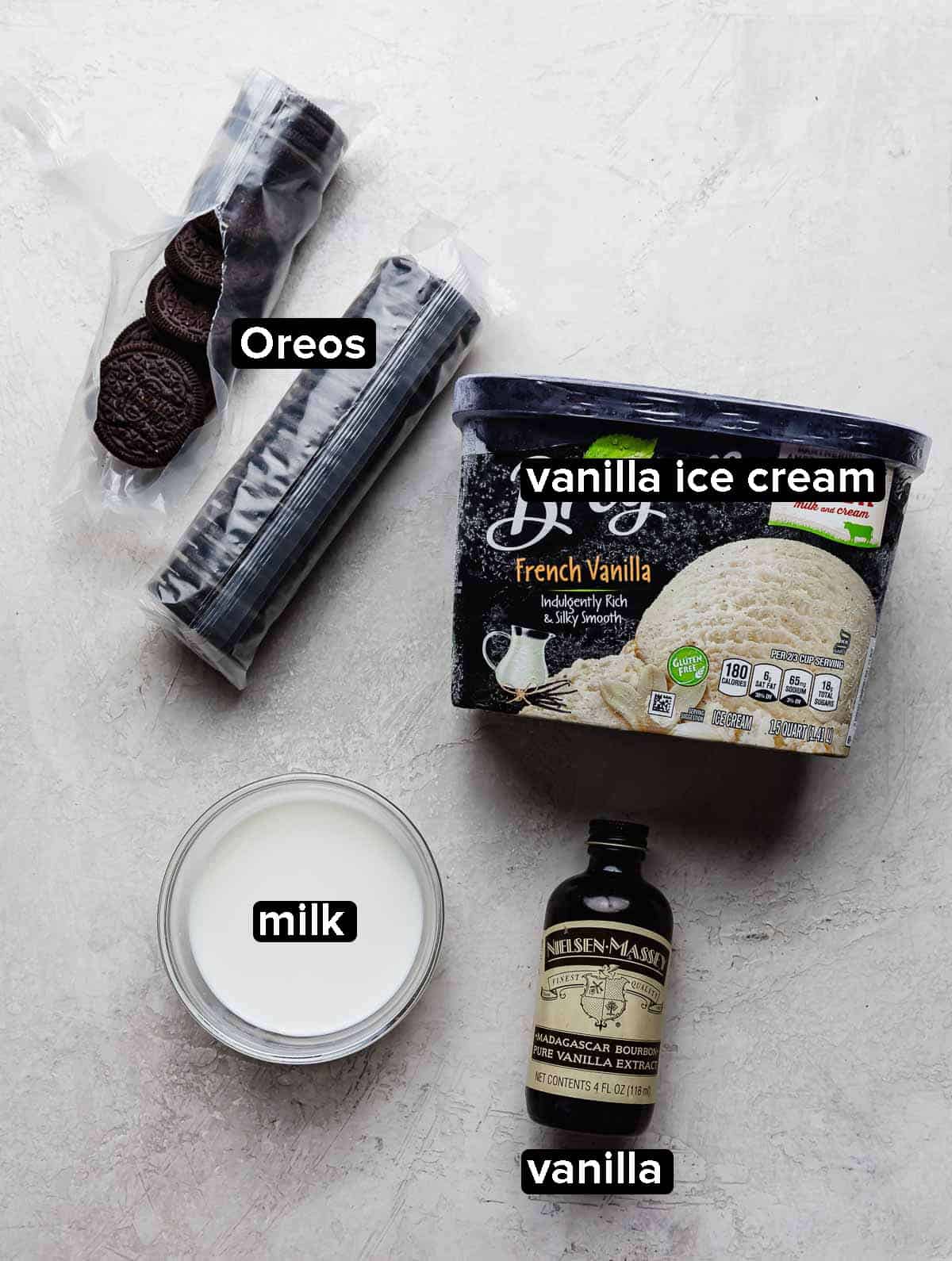 Oreo Milkshake Recipe ingredients on a light gray background: vanilla ice cream, Oreos, vanilla, milk.