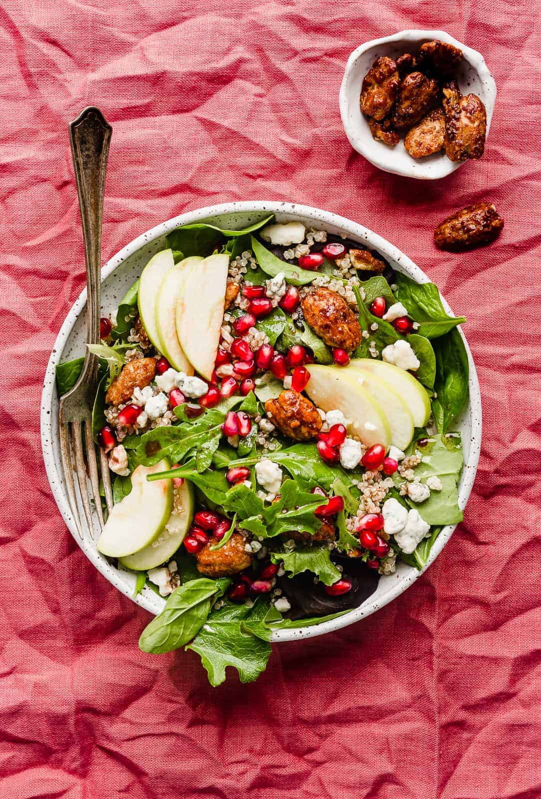 A plate of Pomegranate Salad on a red linen tablecloth.