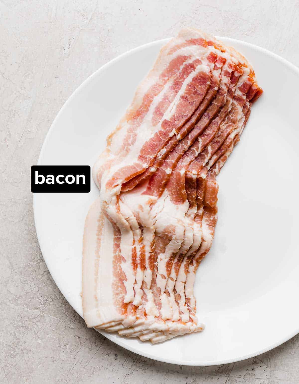 Raw bacon on a white plate.