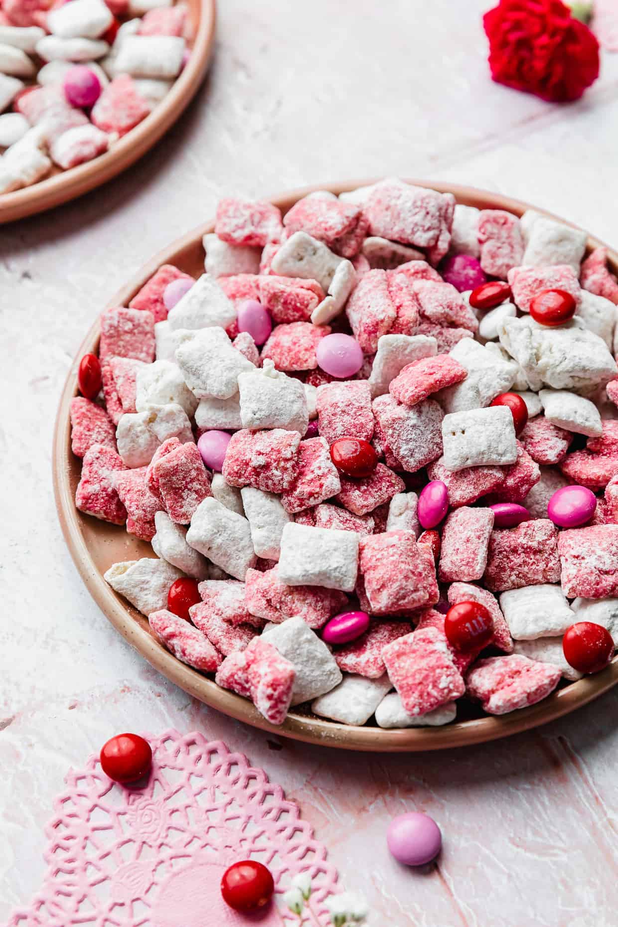 A plate of pink and white muddy buddies on a pink plate. 