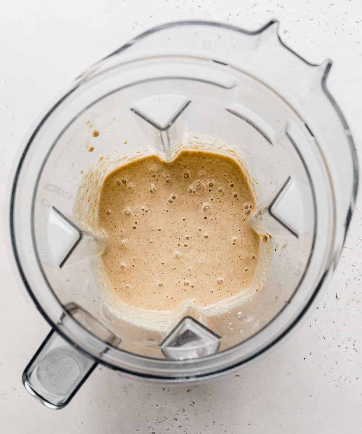 Banana Oatmeal Pancake batter in a blender against a light gray background.