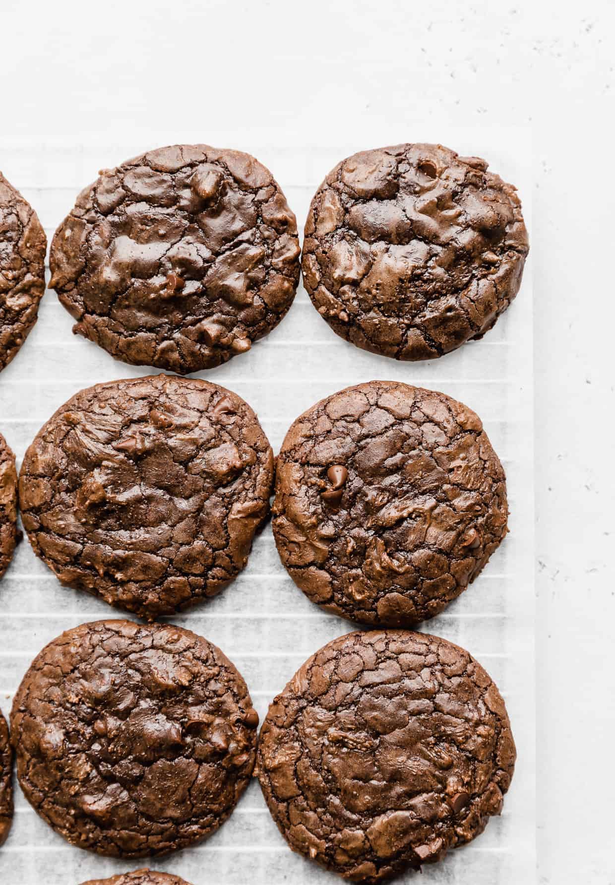 Crackly top brownie mix cookies against a white parchment background.