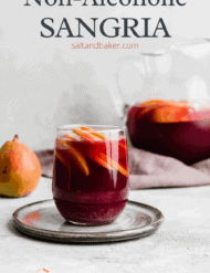 A glass cup full of dark red virgin sangria with sliced fresh fruit.