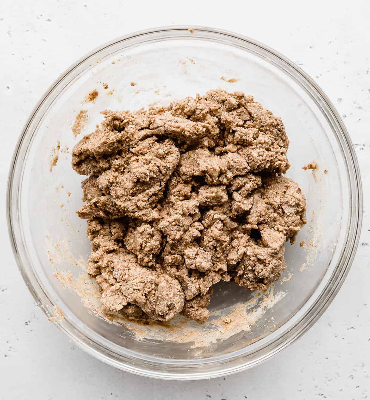 Snickerdoodle Energy Bites batter in a glass bowl against a white background.