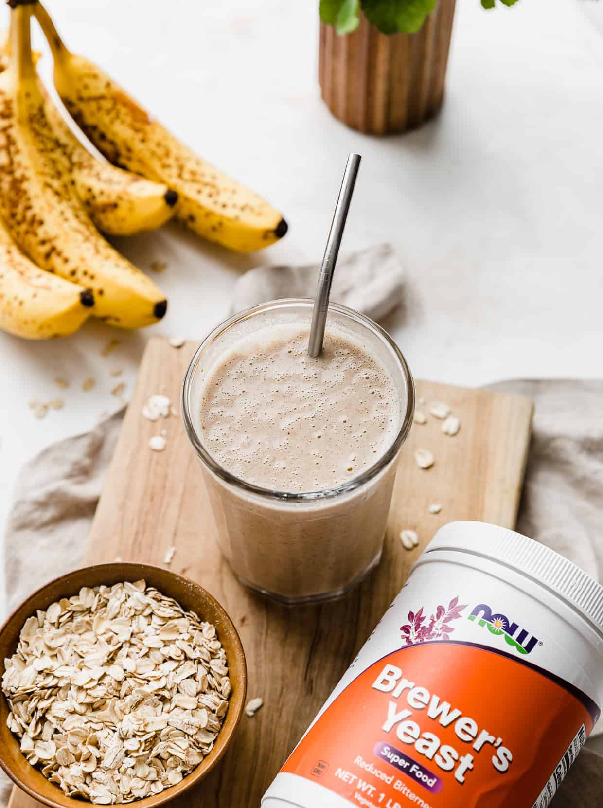 A tan colored Lactation Smoothie on a wooden cutting board. 