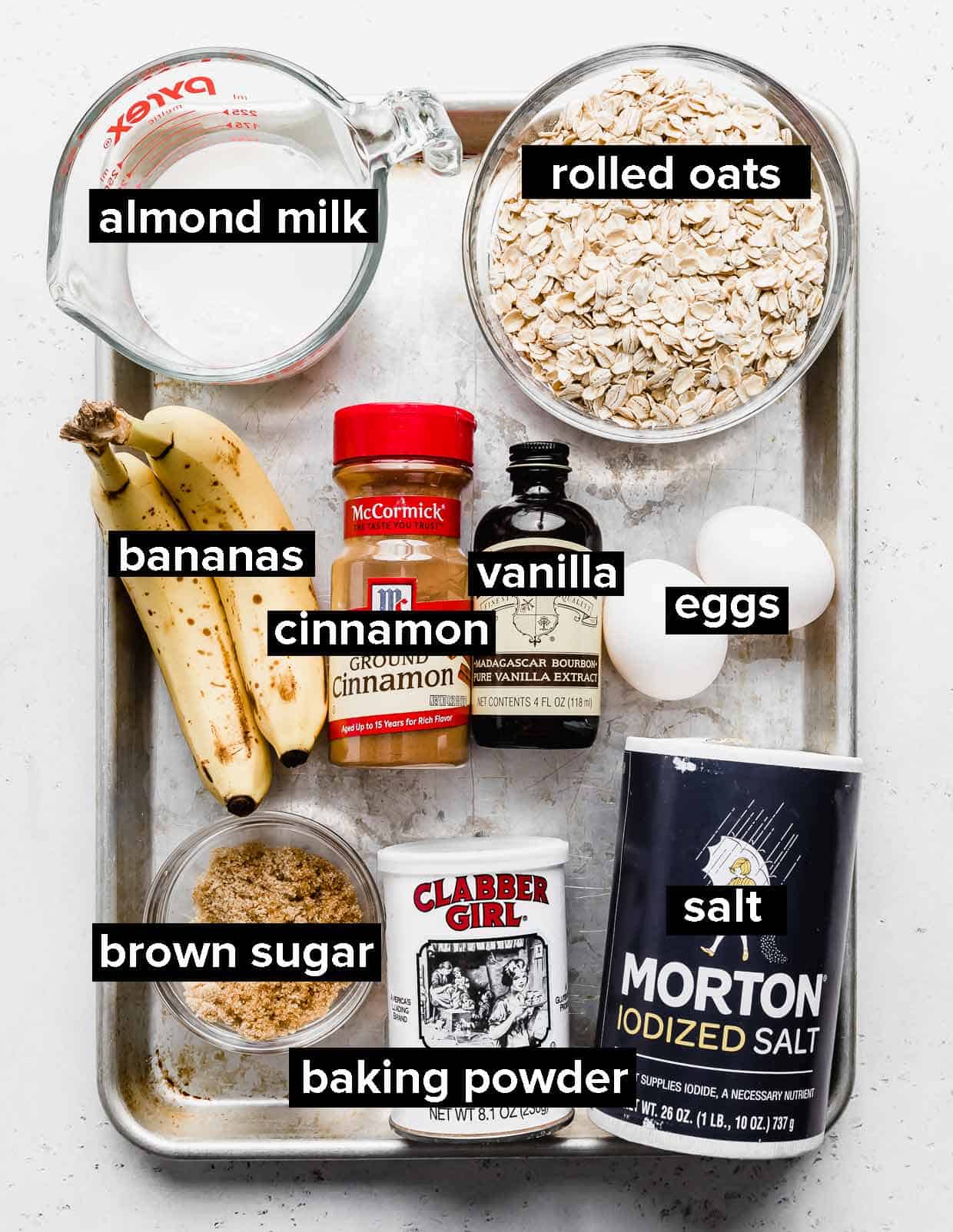 Ingredients used to make banana oatmeal pancakes on a silver baking tray.