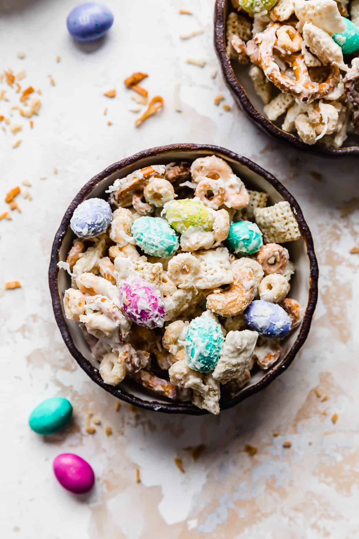 A black rimmed bowl full of "bunny bait" trail mix against a white background. 