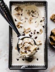 An ice cream scoop with a large scoop of Chocolate Chip Cookie Dough Ice Cream in it.