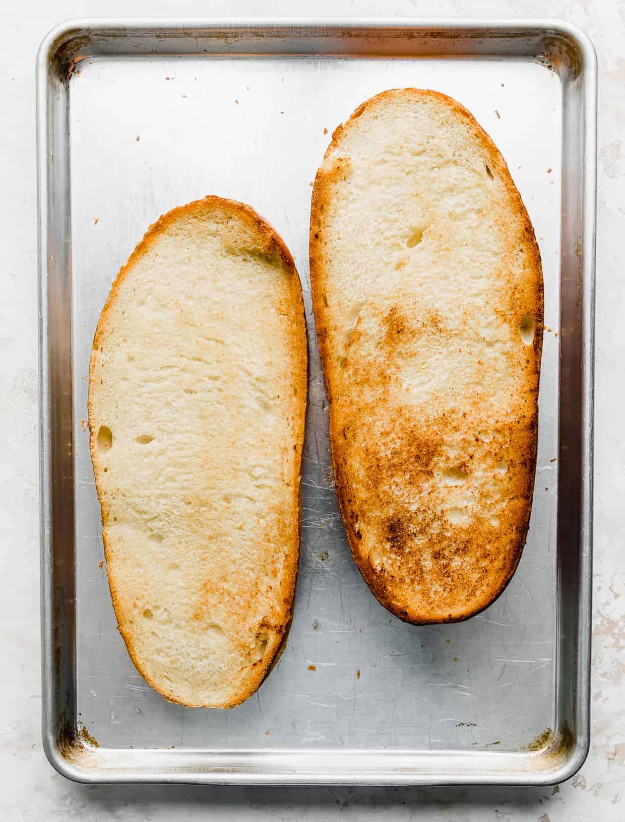 Golden toasted French bread loaf on a baking sheet.