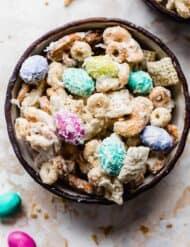 Bunny Bait with peanut butter M&M's, nuts, Cheerios, and coconut, in a black bowl.