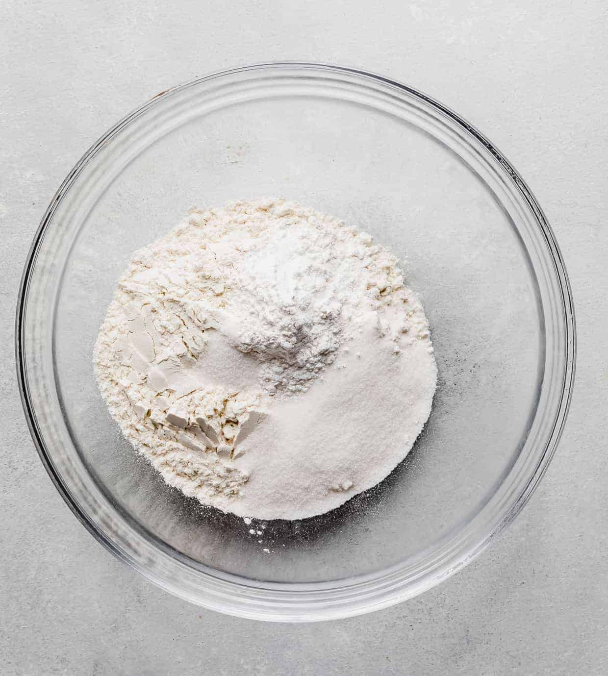 A glass bowl full of flour, baking powder, and salt to make Almond Milk Pancakes.