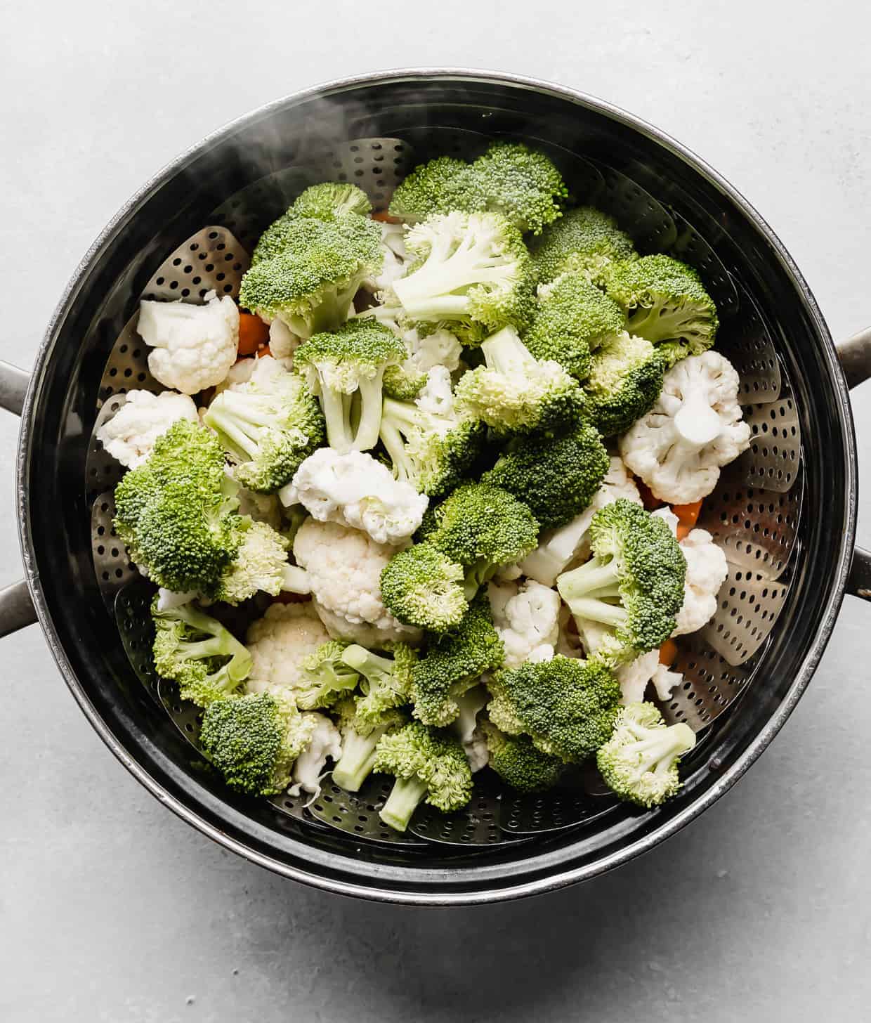 A large pot full of cut broccoli, cauliflower, and carrots.