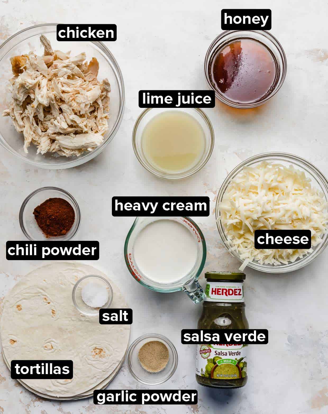 Honey Lime Chicken Enchilada ingredients portioned into glass bowls on a white background.