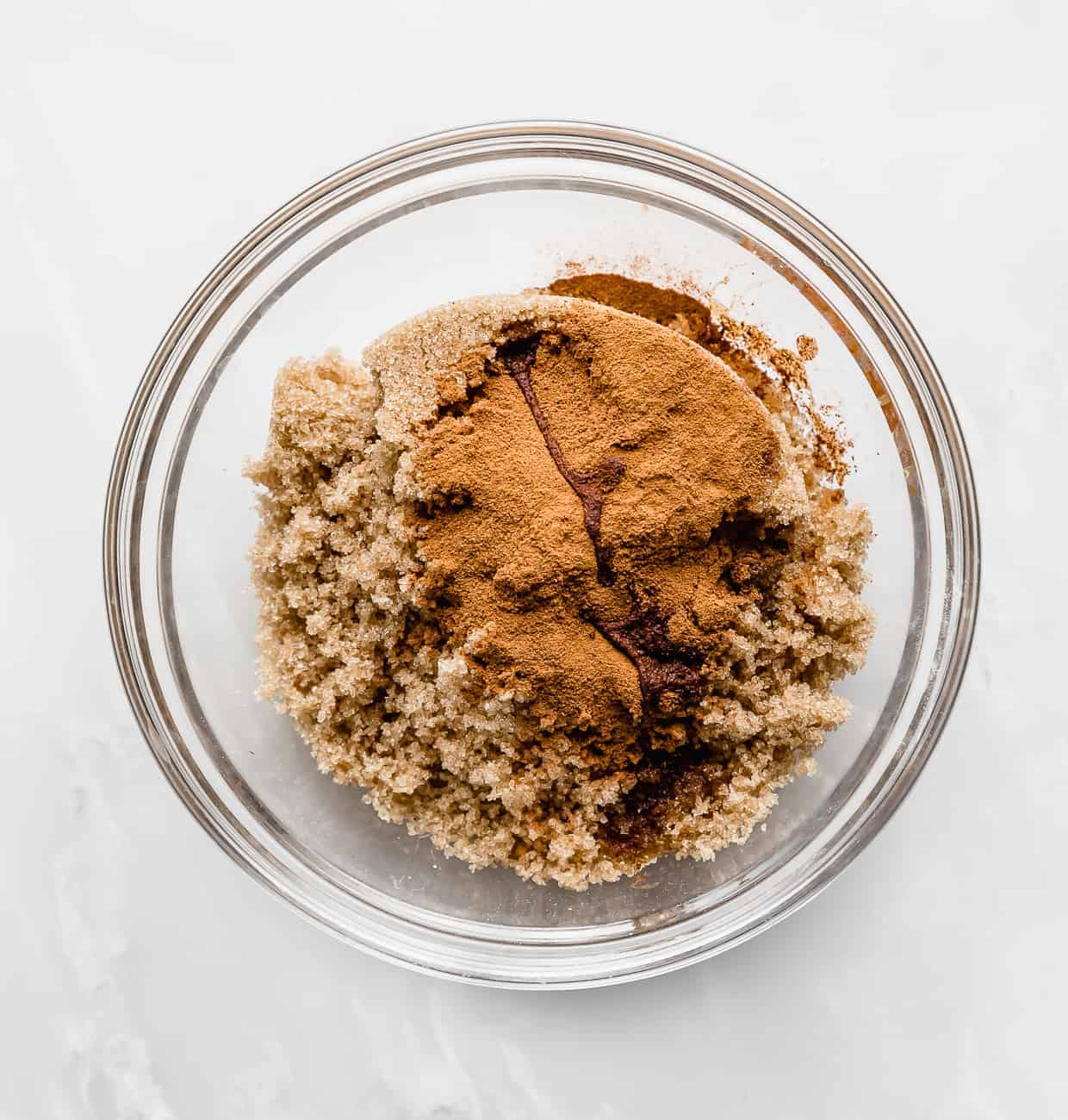 Brown sugar, cinnamon, and extracts in a glass bowl.