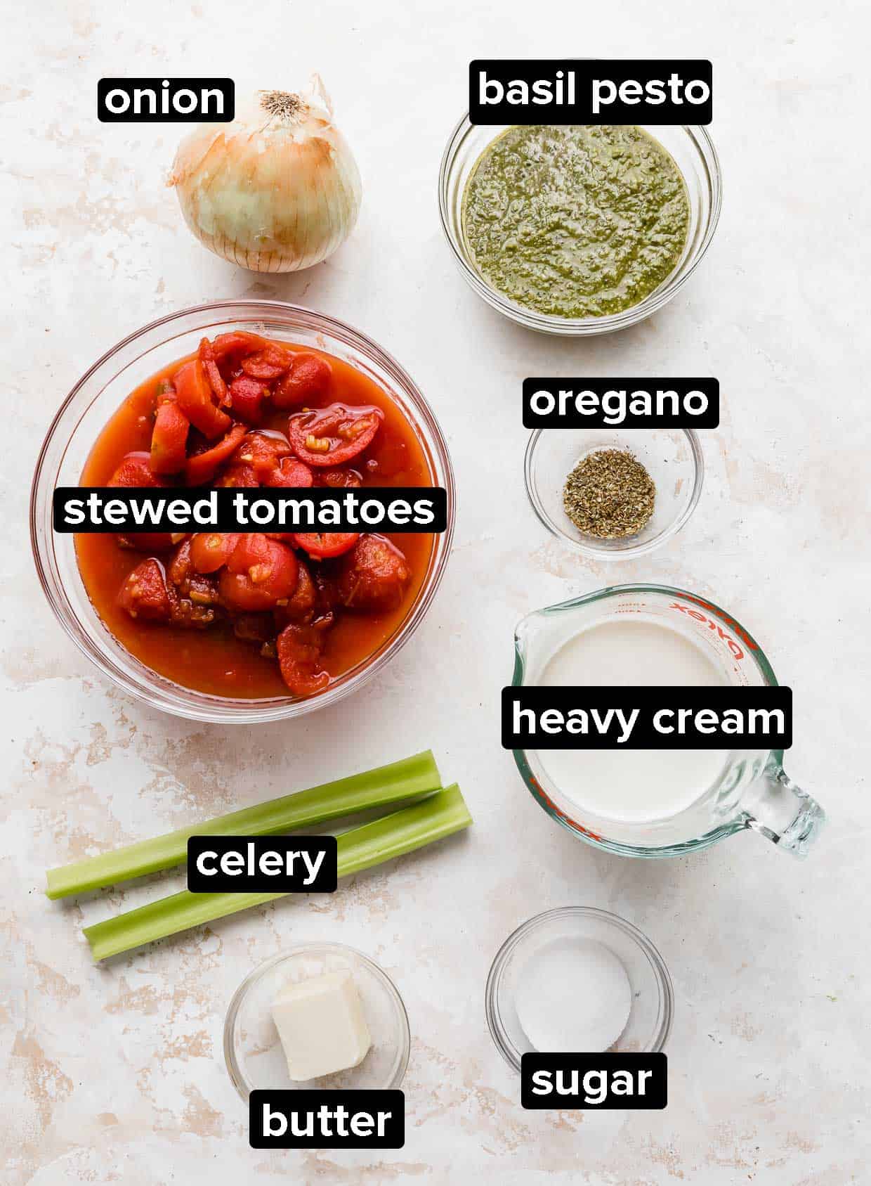 Ingredients used to make Zupas tomato basil soup, on a white textured background.
