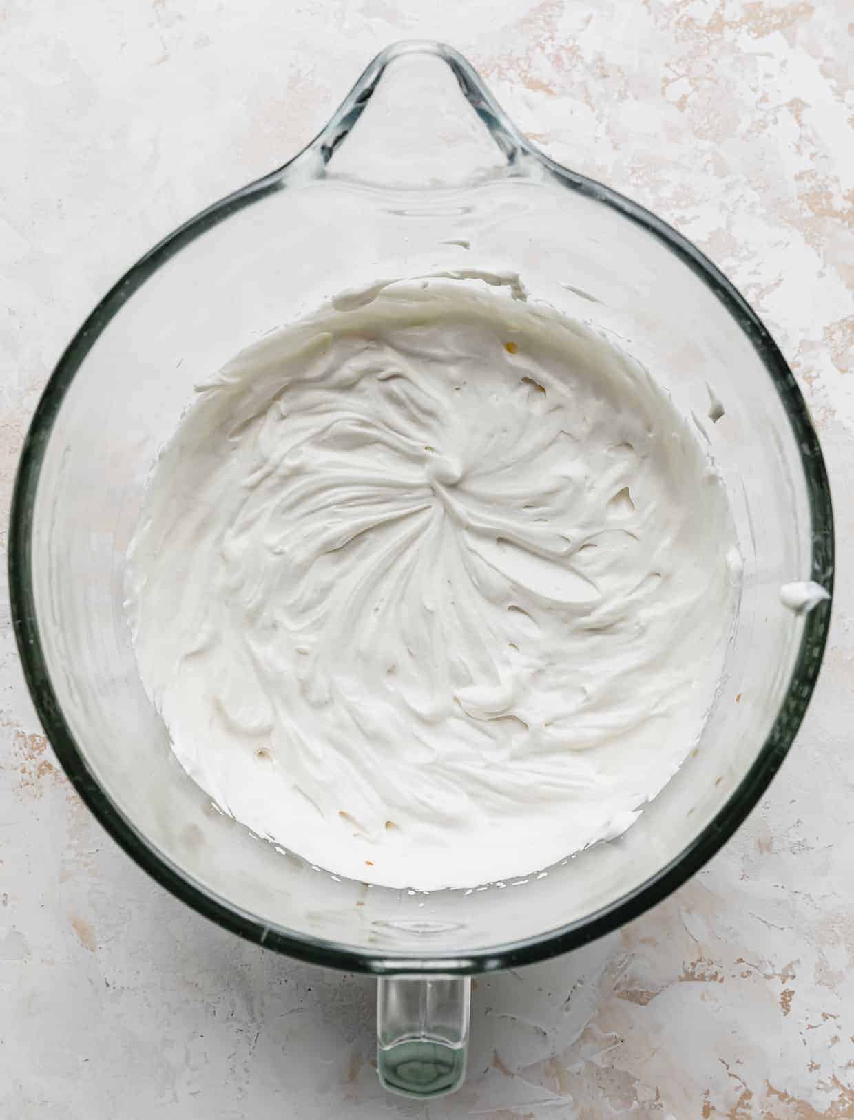 Whipped heavy cream with Greek yogurt in a glass bowl.